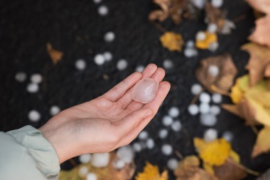 Photo of Woman holding hail grain after thunderstorm outdoors, closeup