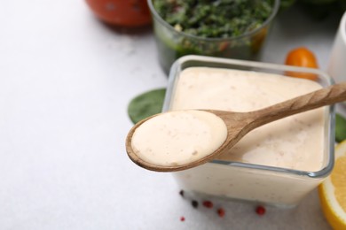 Photo of Bowl and spoon with fresh marinade on table, closeup. Space for text