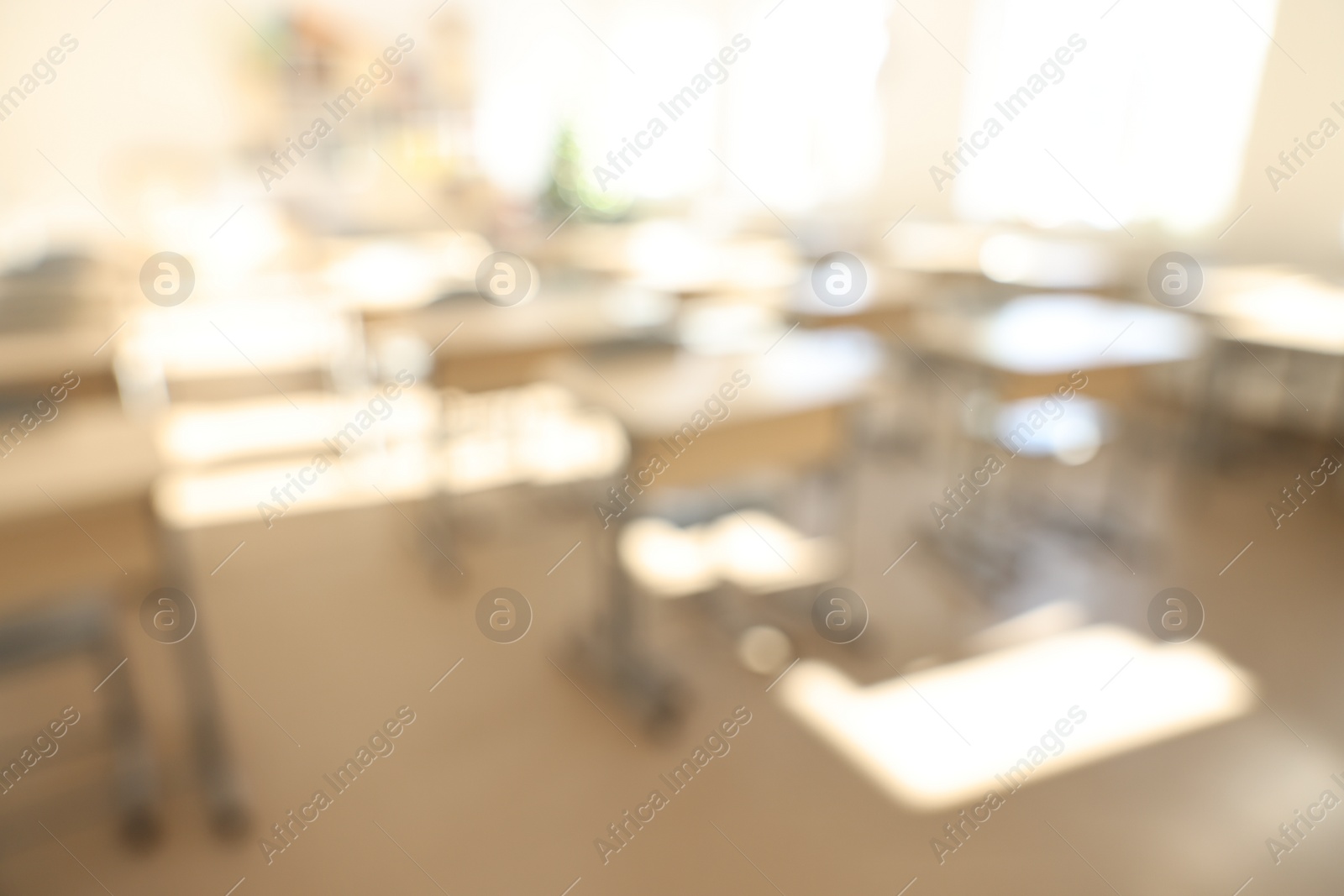 Photo of Blurred view of empty school classroom with desks and chairs