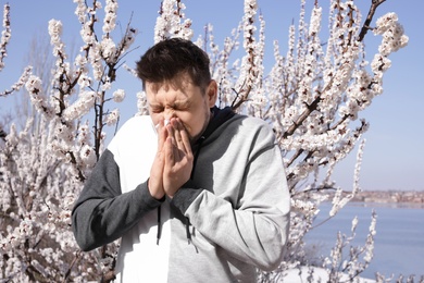 Man suffering from seasonal allergy outdoors on sunny day