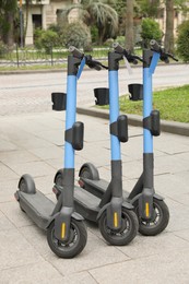 Photo of Modern electric kick scooters on pavement outdoors