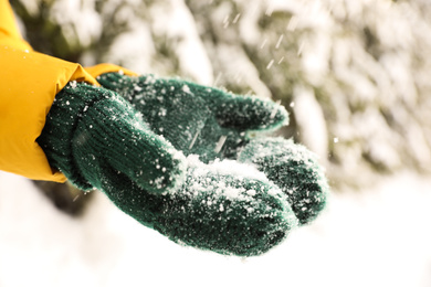 Photo of Woman playing with snow outdoors, closeup. Winter vacation