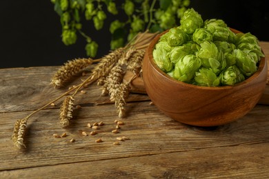 Fresh green hops, wheat grains and spikes on wooden table
