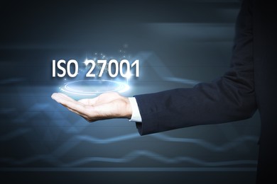 Image of Man demonstrating at virtual icon with text ISO 27001, closeup 