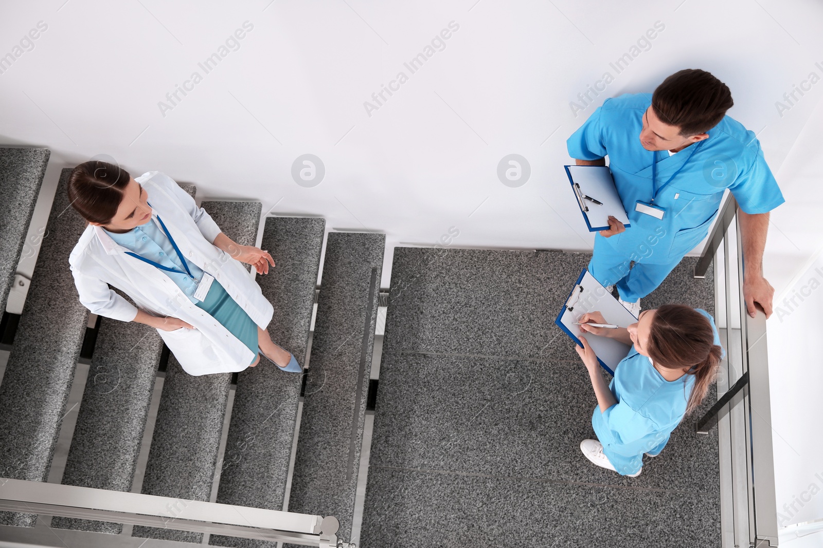 Photo of Team of professional doctors on staircase in clinic