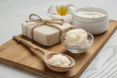 Photo of Board with Shea butter and cosmetic products on table