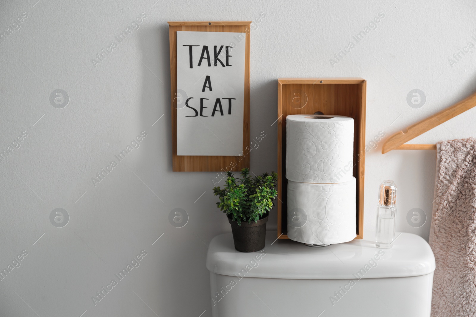 Photo of Decor elements, necessities and toilet bowl near white wall, space for text. Bathroom interior
