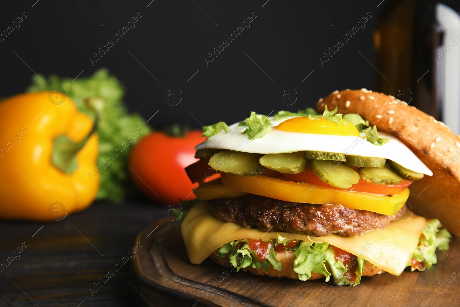 Photo of Tasty burger with fried egg on wooden board, space for text