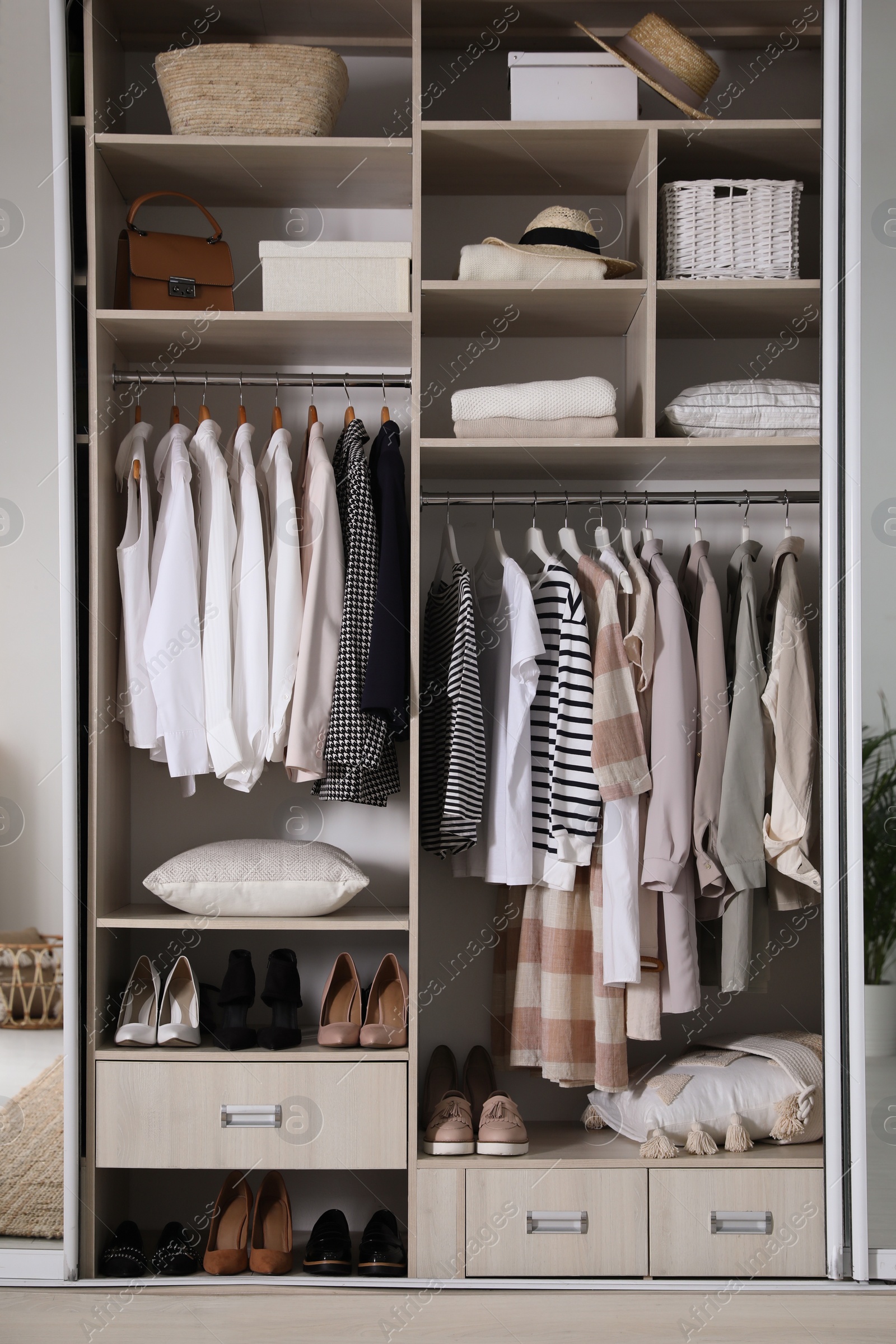 Photo of Wardrobe closet with different stylish clothes, shoes and home stuff in room