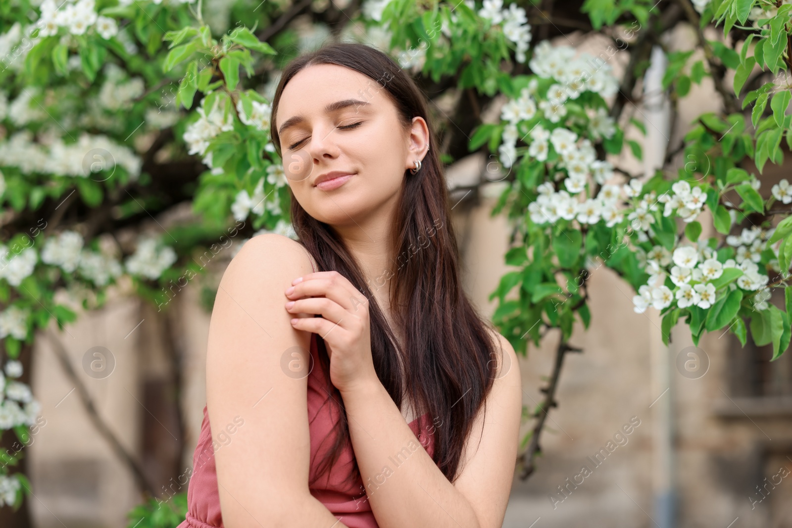 Photo of Beautiful woman near blossoming tree on spring day