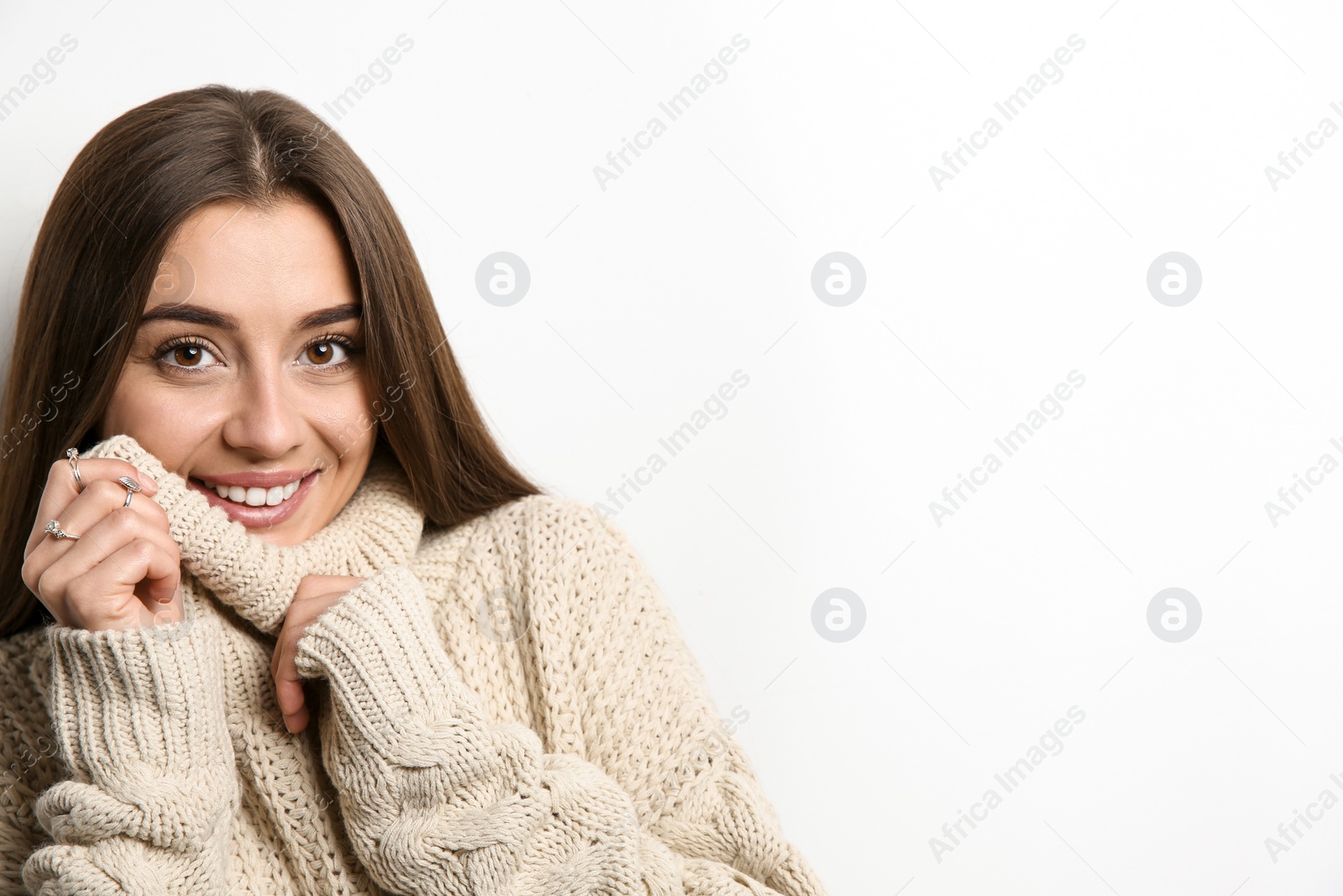 Photo of Beautiful young woman in warm sweater on white background. Space for text