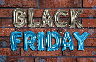 Image of Phrase BLACK FRIDAY made of foil balloon letters against brick wall