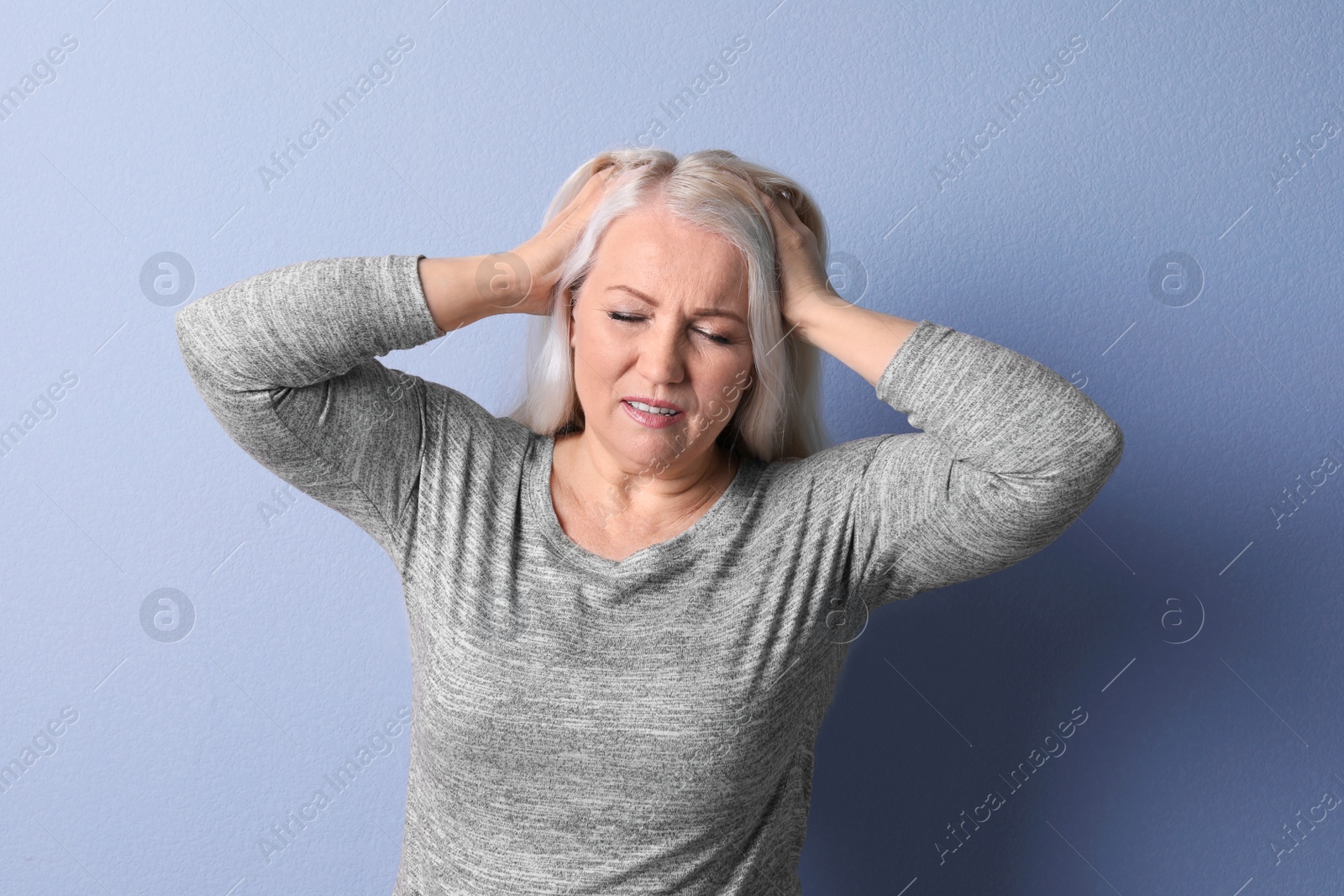 Photo of Mature woman suffering from headache on color background