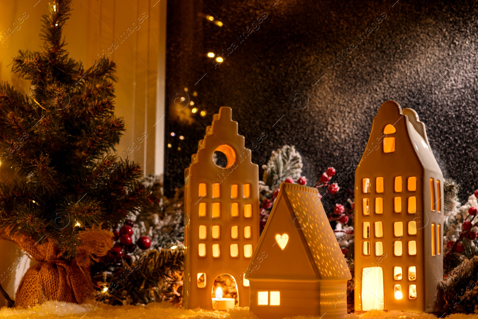 Photo of House shaped lanterns and Christmas decor on windowsill indoors