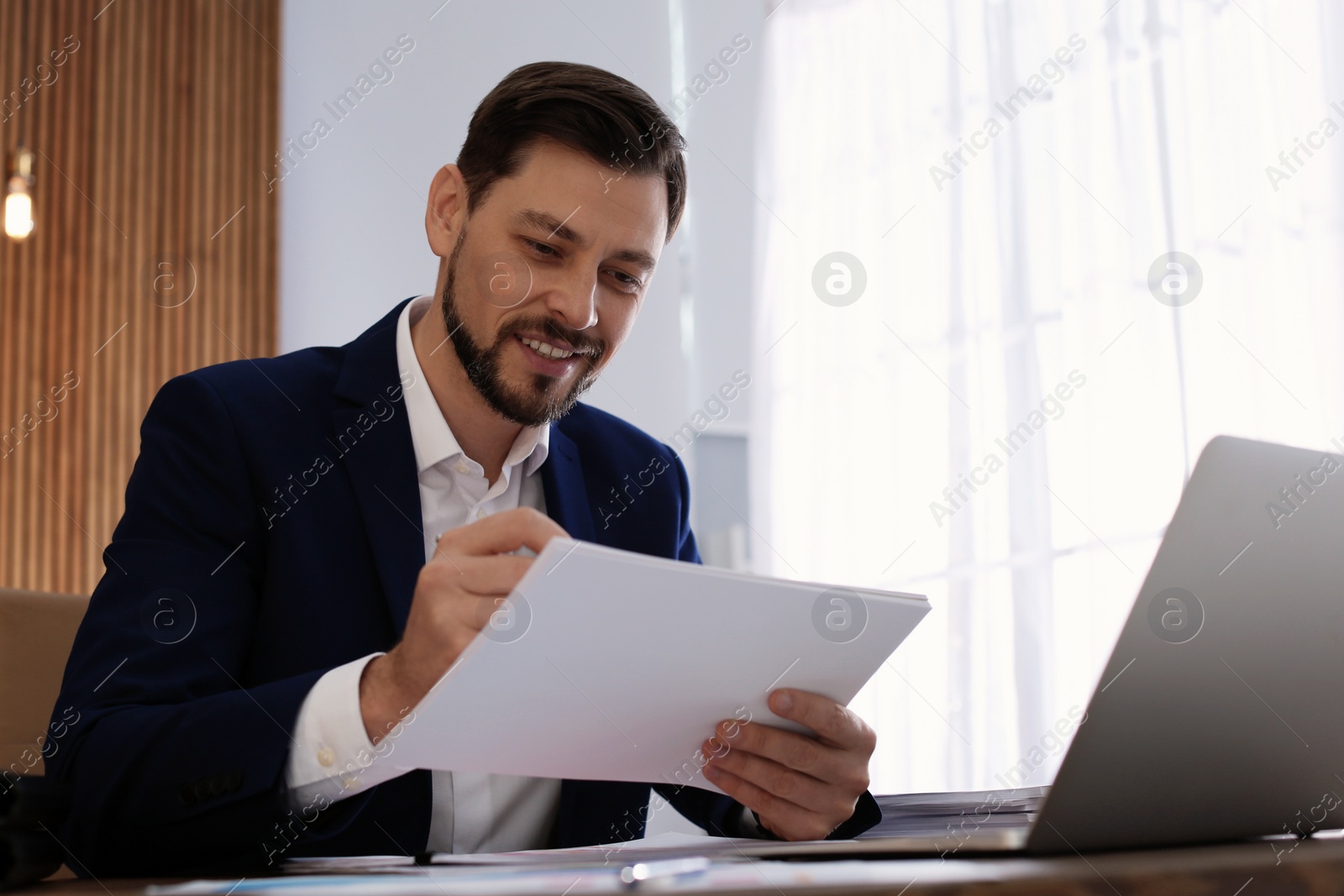 Photo of Businessman working with documents at table in office