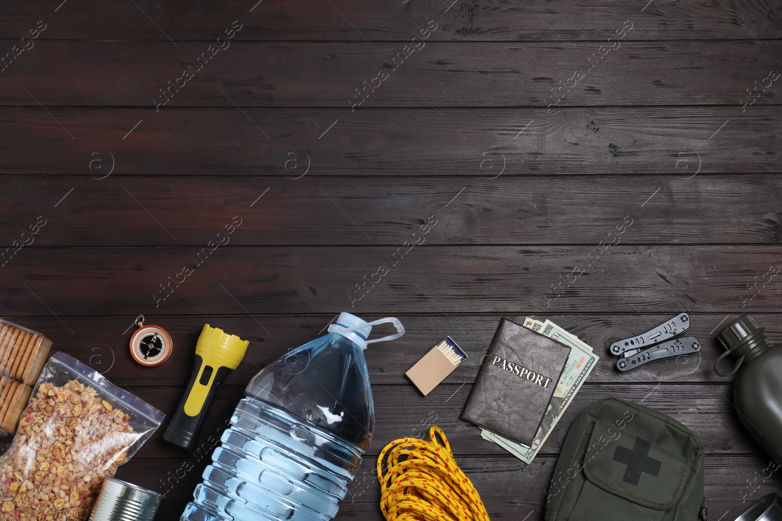 Photo of Earthquake supply kit on dark wooden table, flat lay. Space for text