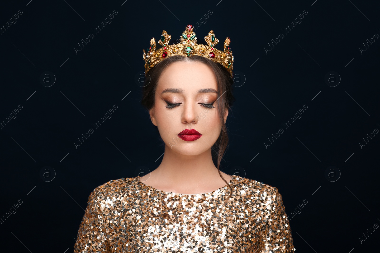 Photo of Beautiful young woman wearing luxurious crown on black background