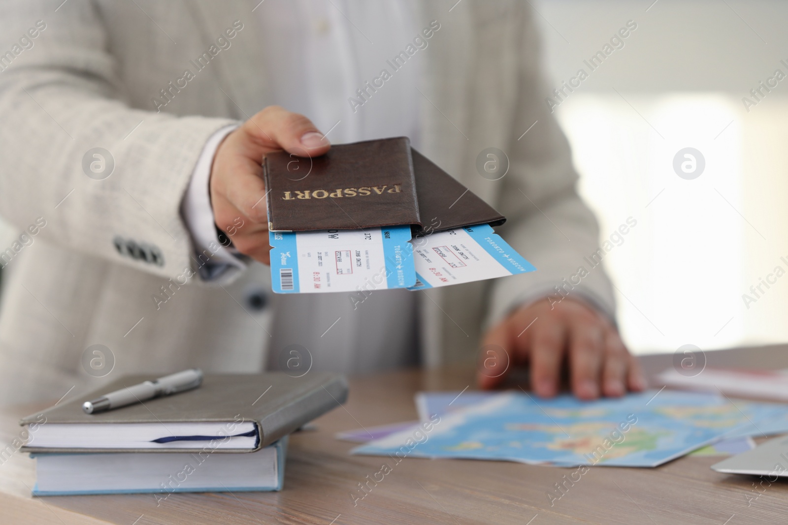 Photo of Travel agent with tickets and passports in office, closeup