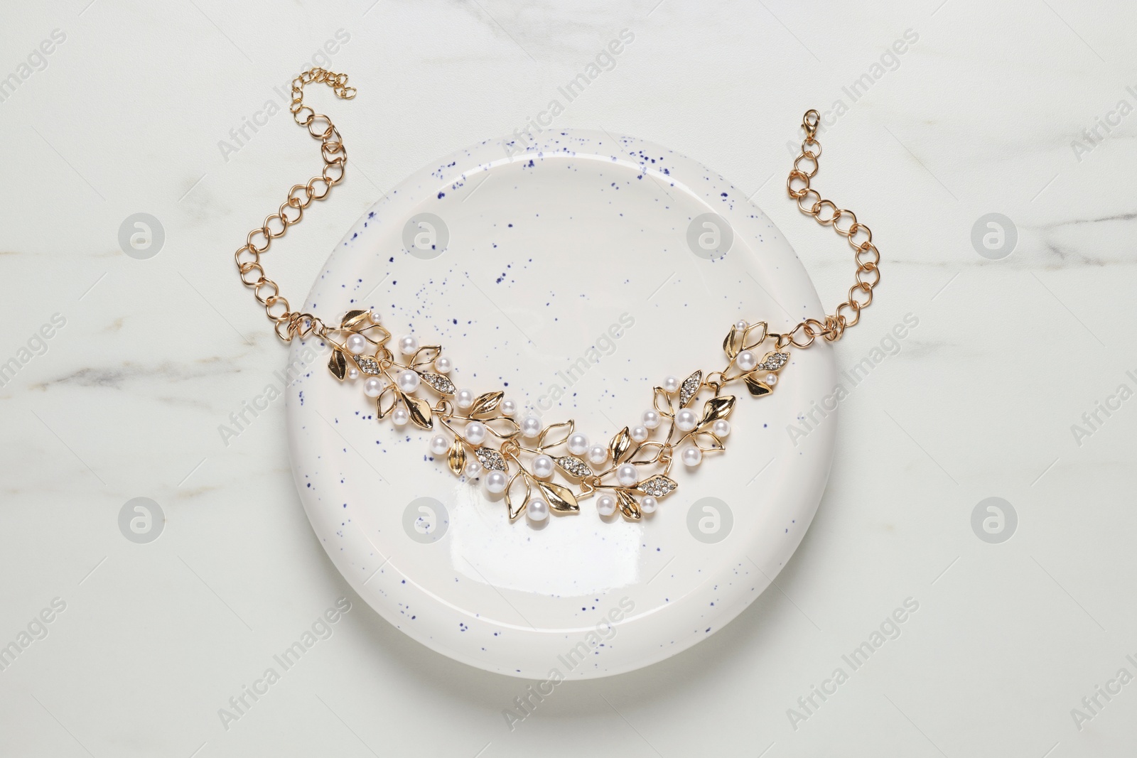 Photo of Beautiful necklace on white marble table, top view. Luxury jewelry