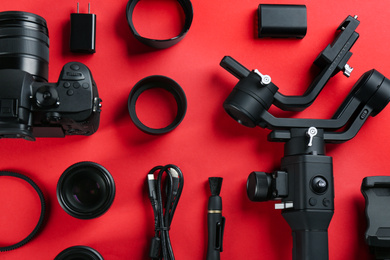 Flat lay composition with camera and video production equipment on red background