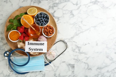 Card with phrase Immune System, medical items and fresh products on light marble table, flat lay. Space for text