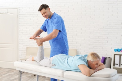 Photo of Physiotherapist working with patient in clinic. Rehabilitation therapy