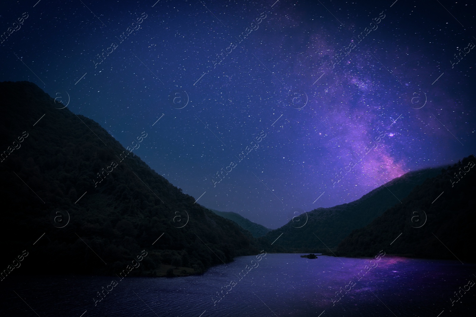 Image of Lake with reflection of starry sky near mountains. Amazing night landscape