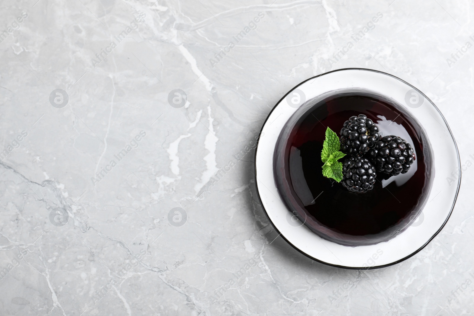 Photo of Delicious jelly with blackberries and mint on grey table, top view. Space for text