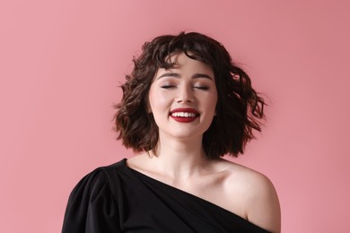 Photo of Portrait of beautiful young woman with wavy hairstyle on pink background