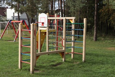 Photo of Colorful wooden outdoor children's playground in park