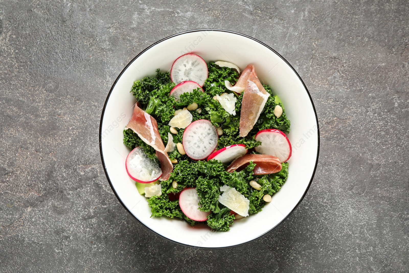 Photo of Tasty fresh kale salad on grey table, top view