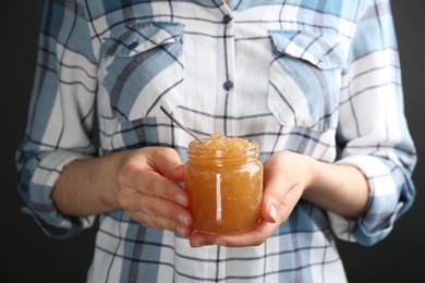 Photo of Woman with jar of delicious pear jam, closeup