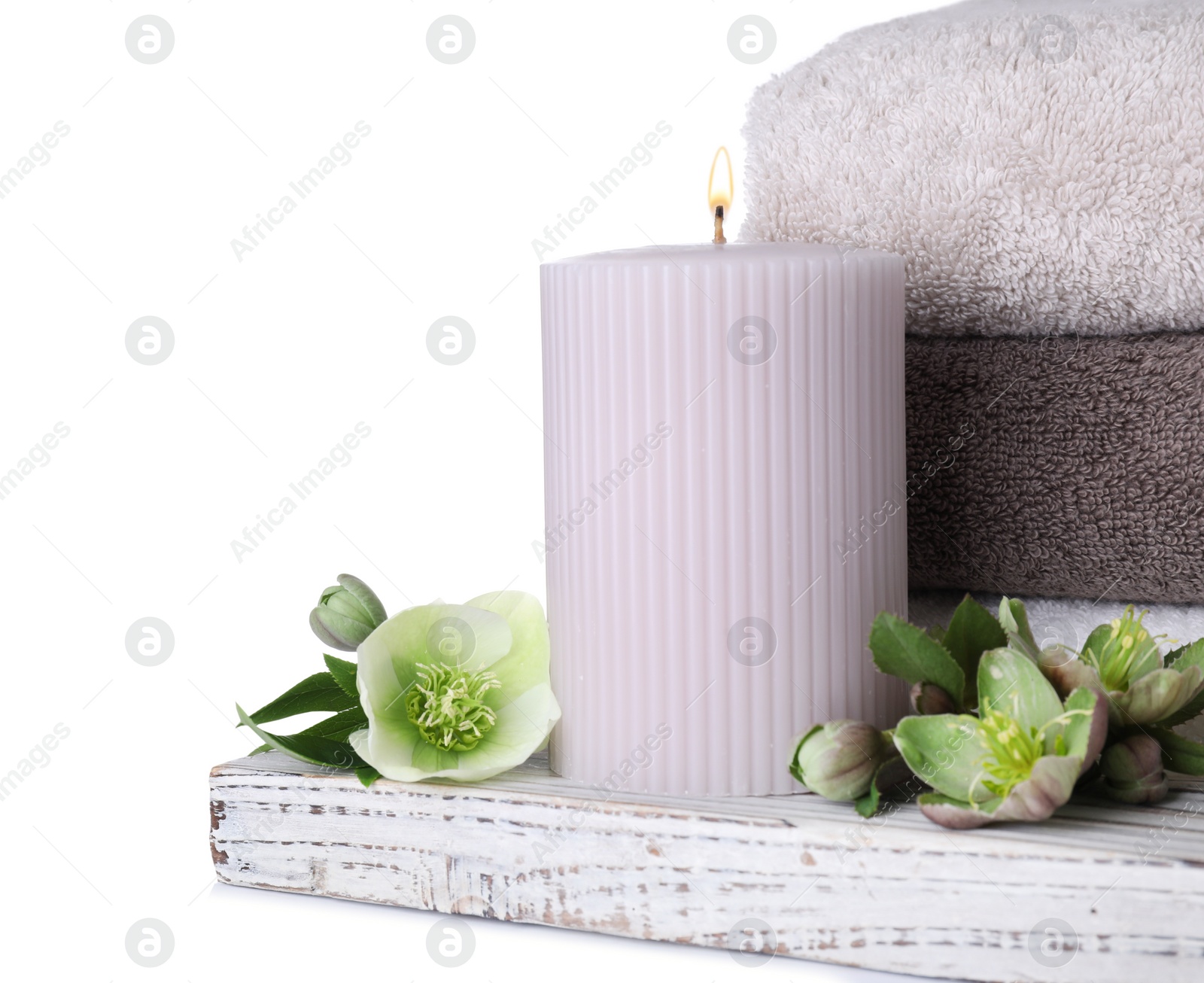 Photo of Composition with towels, candle and flowers isolated on white. Spa treatment