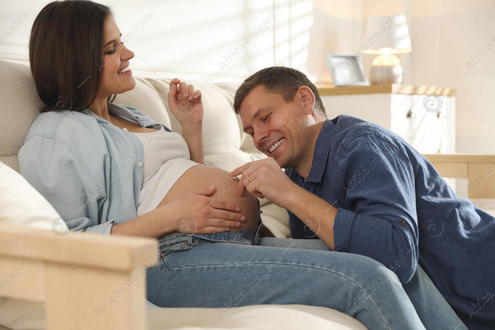 Photo of Young pregnant woman with her husband at home