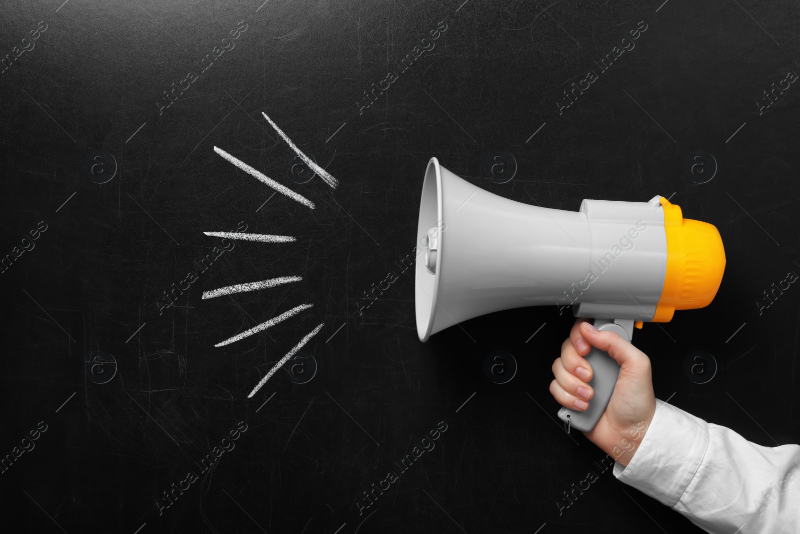 Photo of Man holding megaphone near chalkboard