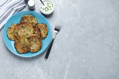 Photo of Delicious zucchini pancakes served on grey table, flat lay. Space for text