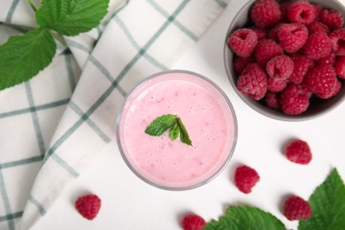 Photo of Tasty fresh raspberry smoothie on white table, flat lay