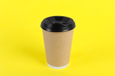 Photo of Paper cup with plastic lid on yellow background. Coffee to go