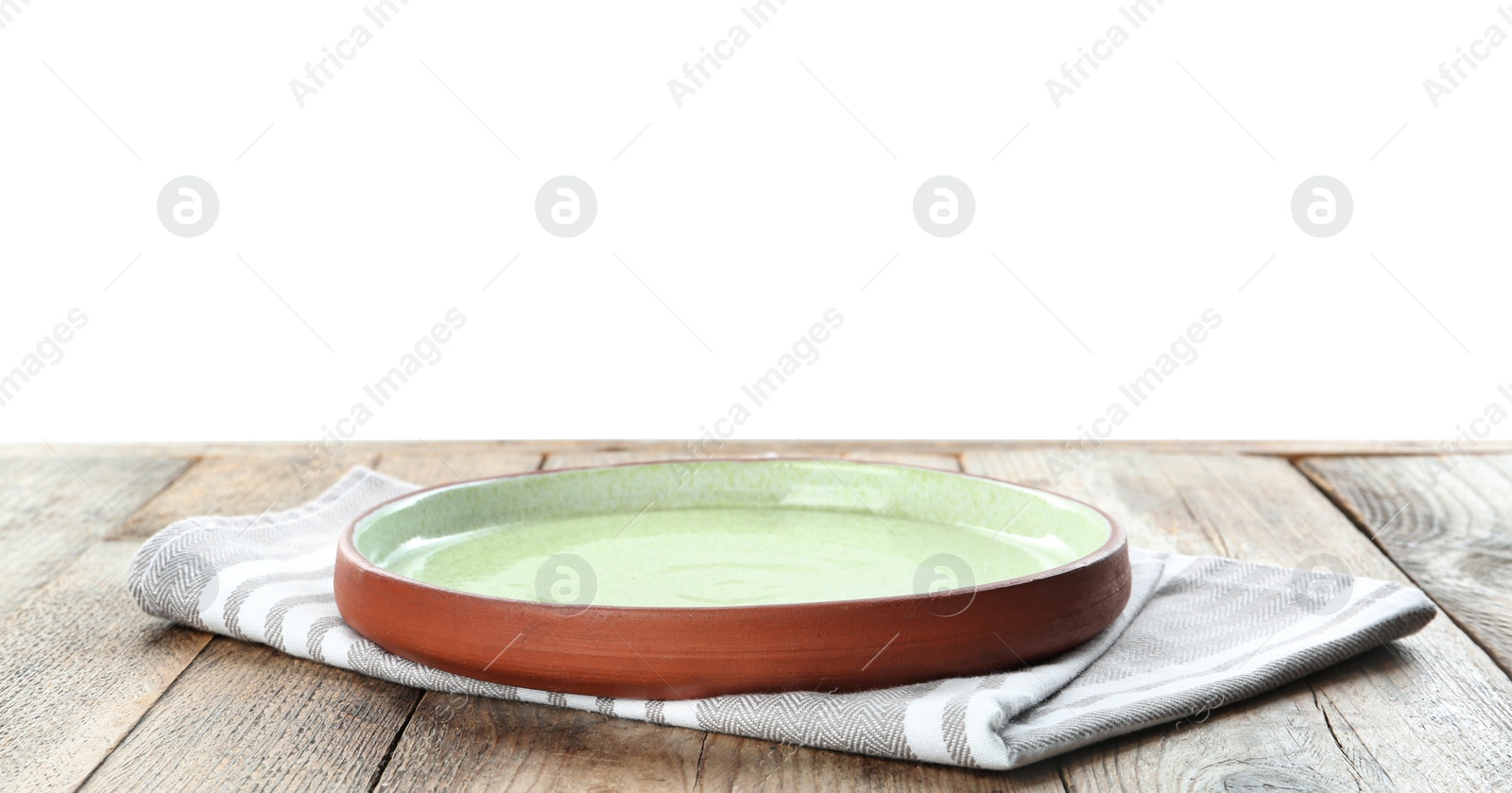 Photo of Empty plate and napkin on wooden table against white background