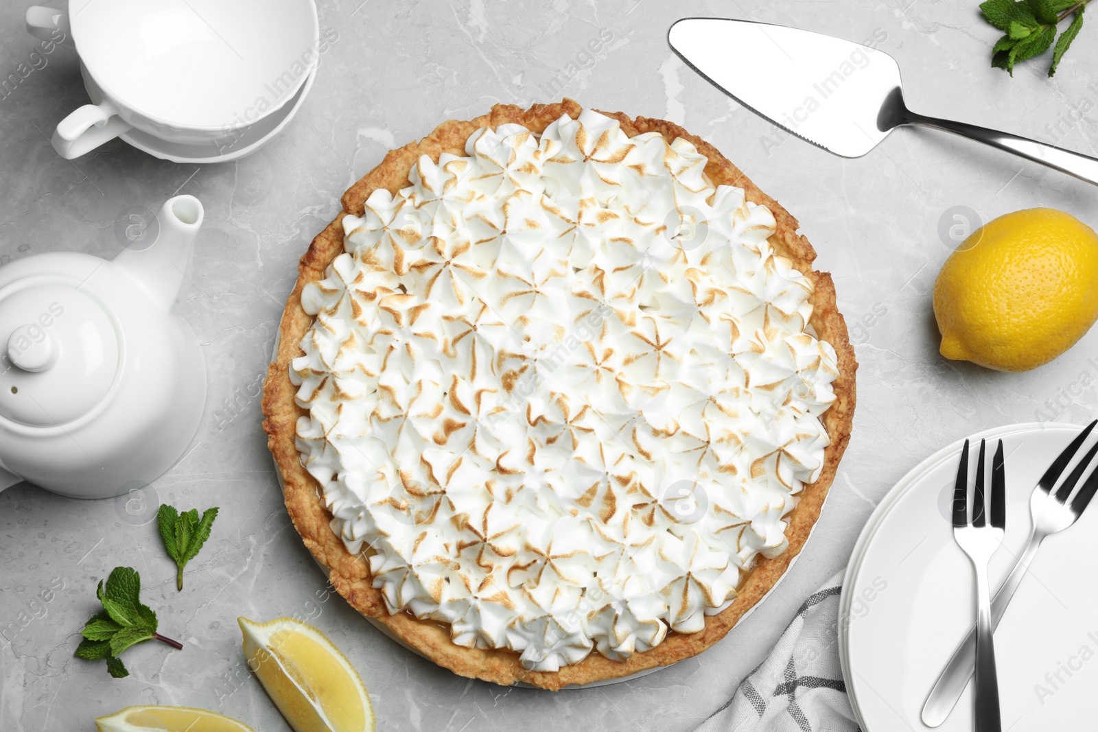 Photo of Flat lay composition with delicious lemon meringue pie on grey table