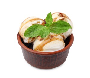 Photo of Tasty ice cream with caramel sauce, mint and nuts in bowl isolated on white