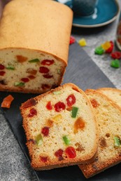 Delicious cake with candied fruits on grey table, above view