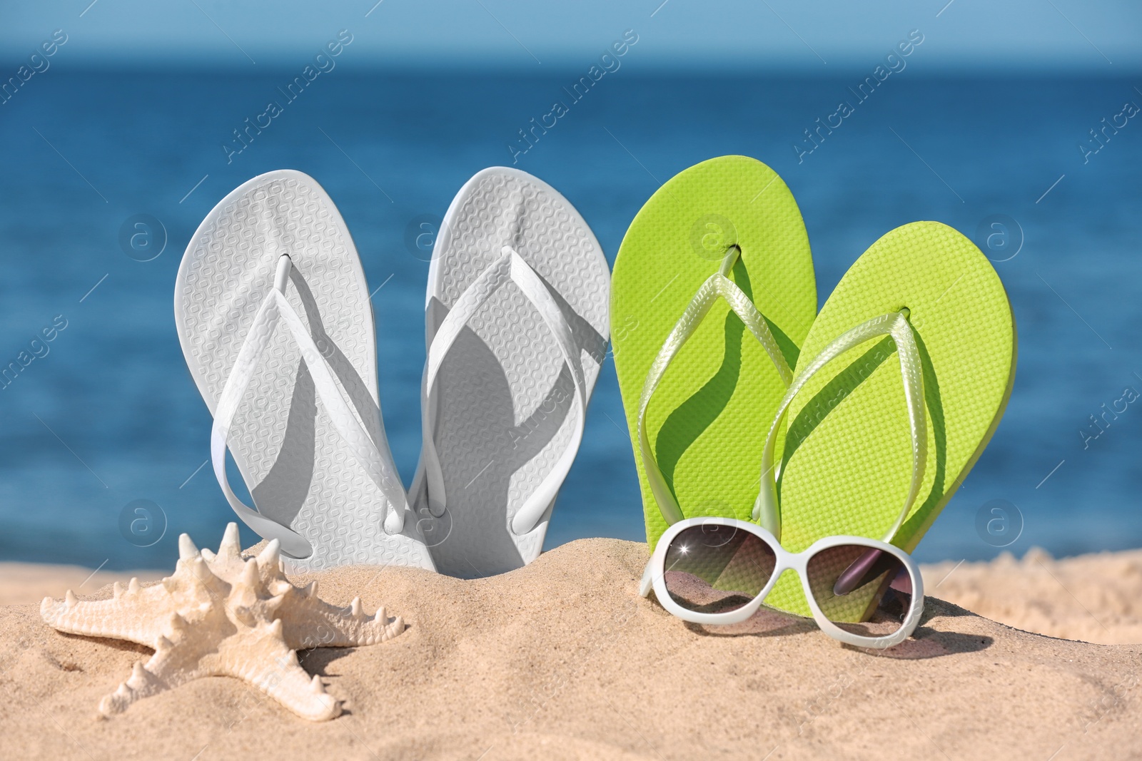 Photo of Composition with beach accessories on sand near sea in summer