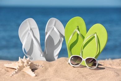 Composition with beach accessories on sand near sea in summer