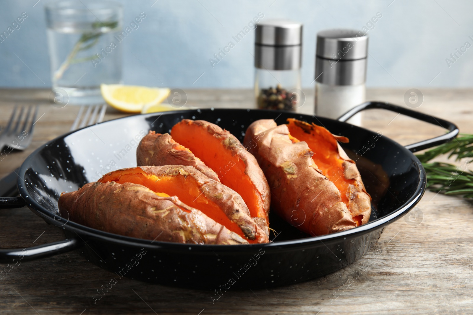 Photo of Dish with baked sweet potatoes on wooden table