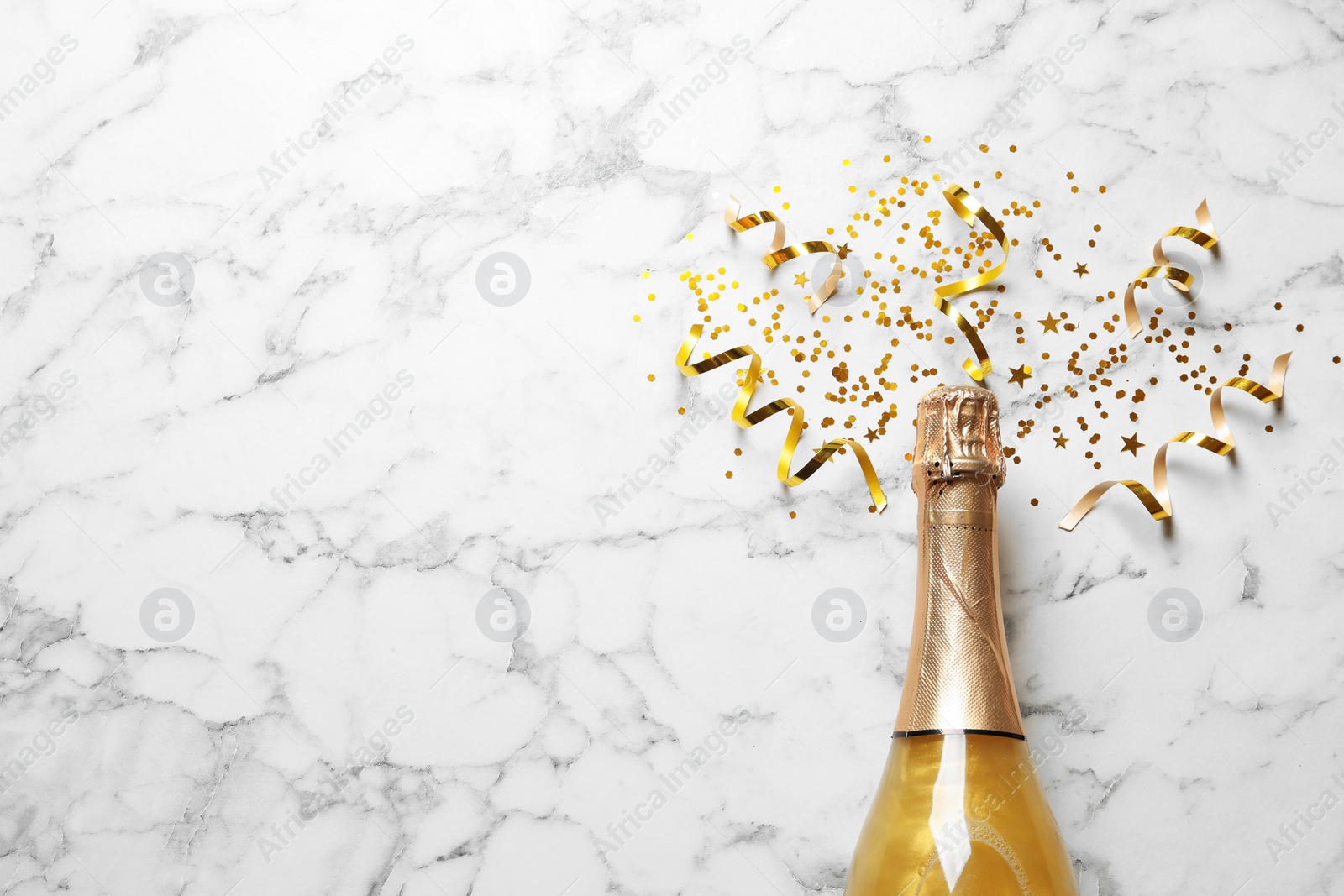 Photo of Flat lay composition with bottle of champagne for celebration on white marble background. Space for text