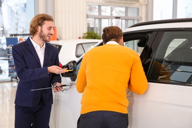 Car salesman working with customer in dealership