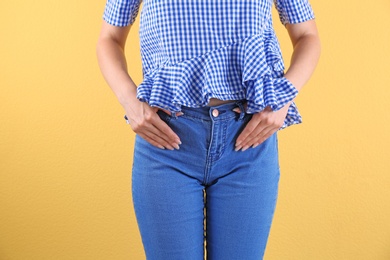 Photo of Woman in stylish blue jeans on color background