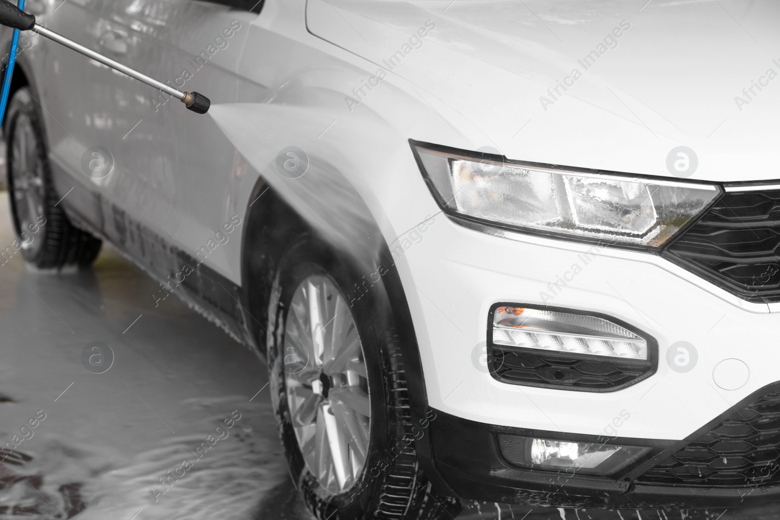 Photo of Washing auto with high pressure water jet at outdoor car wash, closeup