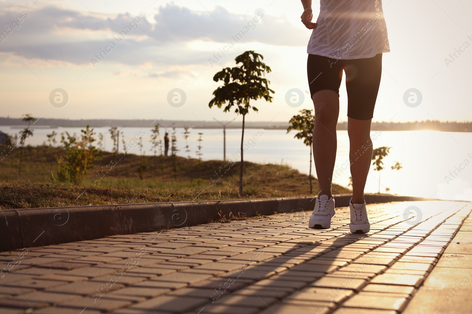 Photo of Young woman running near river in morning, closeup. Space for text